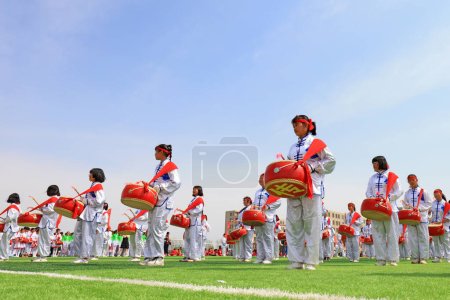 Foto de LUANNAN COUNTY, China - 8 de abril de 2019: La banda de percusión está tocando el tambor en la reunión deportiva, LUANNAN COUNTY, provincia de Hebei, China - Imagen libre de derechos
