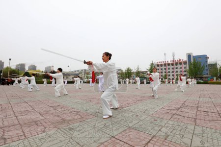 Téléchargez les photos : COMTÉ DE LUANNAN, province du Hebei, Chine - 29 avril 2019 : les gens pratiquent l'épée Tai Chi sur la place du parc. - en image libre de droit