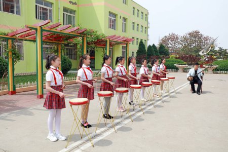 Foto de LUANNAN COUNTY, provincia de Hebei, China - 8 de mayo de 2019: Las niñas están aprendiendo el tradicional tambor chino. - Imagen libre de derechos