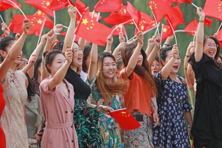 Photo for Luannan County, China - July 5, 2019: People waved flags and sang patriotic songs in the park, Luannan County, Hebei Province, China. - Royalty Free Image