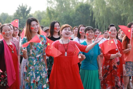 Téléchargez les photos : Comté de Luannan, Chine - 5 juillet 2019 : Des gens agitaient des drapeaux et chantaient des chansons patriotiques dans le parc, comté de Luannan, province du Hebei, Chine. - en image libre de droit