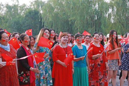Luannan County, China - July 5, 2019: People waved flags and sang patriotic songs in the park, Luannan County, Hebei Province, China.