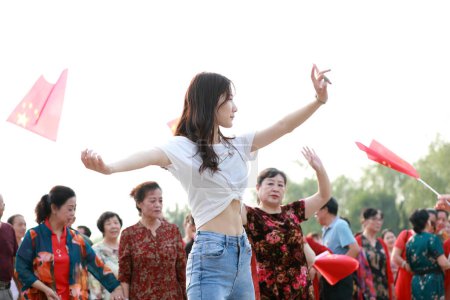 Photo for Luannan County, China - July 5, 2019: A young lady was dancing in the park, Luannan County, Hebei Province, China. - Royalty Free Image