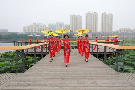 Téléchargez les photos : Comté de Luannan, Chine - 9 juillet 2019 : Des femmes en cheongsams rouges jouent dans un défilé, comté de Luannan, province du Hebei, Chine - en image libre de droit