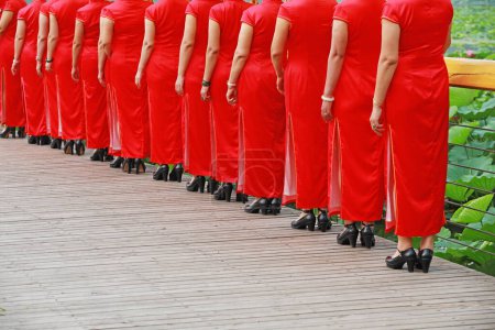 Téléchargez les photos : Les femmes en cheongsams rouges jouent dans un spectacle de marche, comté de Luannan, province du Hebei, Chine - en image libre de droit