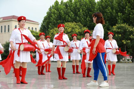 Téléchargez les photos : Comté de Luannan, Chine - 11 juillet 2019 : Une jeune femme a demandé à un groupe de femmes âgées de pratiquer le tambour à la taille, comté de Luannan, province du Hebei, Chine - en image libre de droit