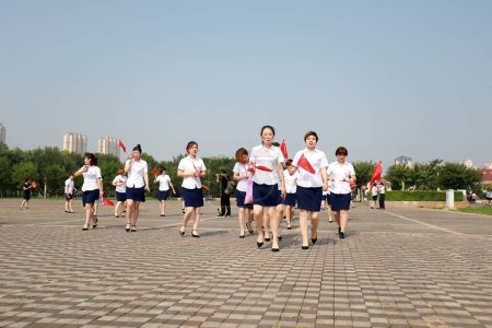 Téléchargez les photos : Comté de Luannan, Chine - 12 juillet 2019 : Des dames marchent avec le drapeau chinois dans le parc, comté de Luannan, province du Hebei, Chine - en image libre de droit