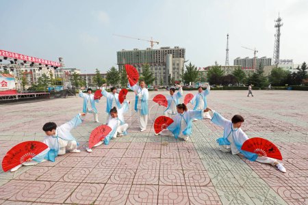 Photo for LUANNAN COUNTY, Hebei Province, China - August 8, 2019: Tai Chi Kung Fu Fan performed in the park square. - Royalty Free Image