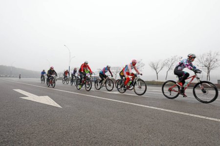 Foto de CONDADO DE LUANNAN, provincia de Hebei, China - 23 de noviembre de 2019: Los ciclistas están tratando de avanzar, en un sitio de competición de ciclismo de carretera. - Imagen libre de derechos