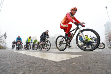 Foto de CONDADO DE LUANNAN, provincia de Hebei, China - 23 de noviembre de 2019: Los ciclistas están tratando de avanzar, en un sitio de competición de ciclismo de carretera. - Imagen libre de derechos