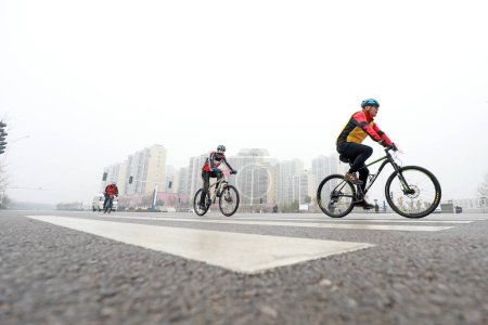 Téléchargez les photos : COMTÉ DE LUANNAN, province du Hebei, Chine - 23 novembre 2019 : Les cyclistes tentent d'aller de l'avant, sur un site de compétition cycliste sur route. - en image libre de droit