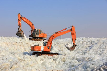 Photo for LUANNAN COUNTY, Hebei Province, China - January 14, 2020: Farmers use excavators to pack ice in a storage site - Royalty Free Image