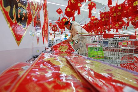 Téléchargez les photos : COMTÉ DE LUANNAN, Province du Hebei, Chine - 17 janvier 2020 : Les clients dans la sélection de papiers découpés dans le centre commercial à la veille du Festival de printemps. - en image libre de droit