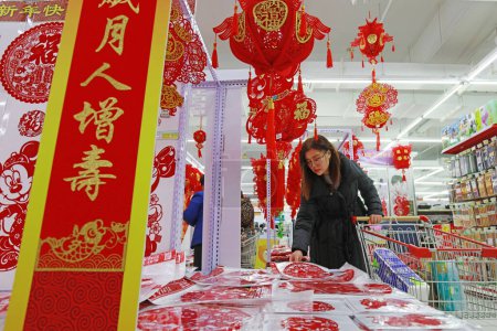 Téléchargez les photos : COMTÉ DE LUANNAN, Province du Hebei, Chine - 17 janvier 2020 : Les clients dans la sélection de papiers découpés dans le centre commercial à la veille du Festival de printemps. - en image libre de droit