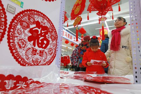 Photo for LUANNAN COUNTY, Hebei Province, China - January 17, 2020: Customers in the selection of paper-cut works in the mall on the eve of the Spring Festival. - Royalty Free Image
