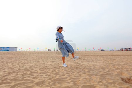 Photo for LUANNAN COUNTY, Hebei Province, China - May 3, 2019: A girl is playing on the beach. - Royalty Free Image