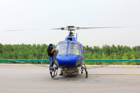 Téléchargez les photos : Comté de Luannan, Chine - 16 juin 2019 : Les travailleurs essuient les pare-brise des hélicoptères agricoles, comté de Luannan, province du Hebei, Chine - en image libre de droit