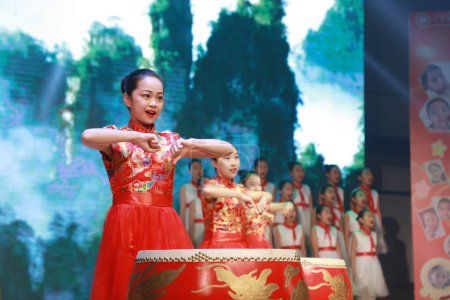 Photo for LUANNAN COUNTY, China - April 19, 2019: The little girls are playing drums on the stage, LUANNAN COUNTY, Hebei Province, China - Royalty Free Image