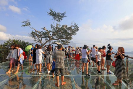 Foto de Ciudad de Sanya, China - 1 de abril de 2019: los turistas juegan en el caballete de cristal con vista al mar, Ciudad de Sanya, provincia de Hainan, China - Imagen libre de derechos