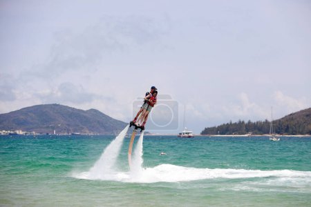Foto de Ciudad de Sanya, China - 1 de abril de 2019: Proyecto de diversión del hombre volador de agua en la bahía de Yalong, ciudad de Sanya, provincia de Hainan, China - Imagen libre de derechos