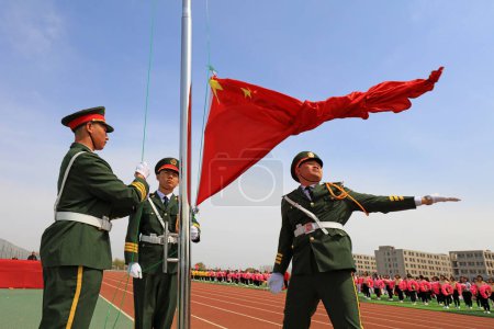 Foto de CONDADO DE LUANNAN, China - 8 de abril de 2019: Soldados de la policía armada en la ceremonia de izamiento de la bandera, CONDADO DE LUANNAN, Provincia de Hebei, China - Imagen libre de derechos