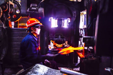 Foto de LUANNAN COUNTY, provincia de Hebei, China - 15 de abril de 2019: los trabajadores trabajan en una línea de blanqueo de placas de acero en una planta de producción de palas de acero. - Imagen libre de derechos