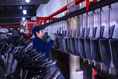 Téléchargez les photos : COMTÉ DE LUANNAN, province du Hebei, Chine - 15 avril 2019 : Les travailleurs sont occupés sur la ligne de production d'une usine de production de pelles en acier. - en image libre de droit