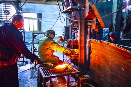 Photo for LUANNAN COUNTY, Hebei Province, China - April 15, 2019: workers work on a steel plate blanking line in a steel shovel production plant. - Royalty Free Image