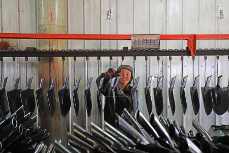 Téléchargez les photos : COMTÉ DE LUANNAN, province du Hebei, Chine - 15 avril 2019 : Les travailleurs sont occupés sur la ligne de production d'une usine de production de pelles en acier. - en image libre de droit