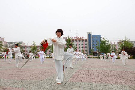Photo for LUANNAN COUNTY, Hebei Province, China - April 29, 2019: people practice Tai Chi Sword in the park square. - Royalty Free Image