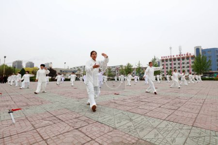 Foto de CONDADO DE LUANNAN, provincia de Hebei, China - 29 de abril de 2019: la gente practica Taijiquan en la plaza del parque. - Imagen libre de derechos