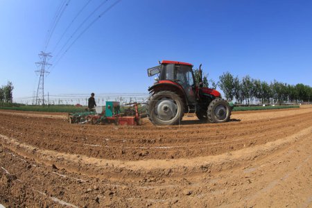 Foto de CONDADO DE LUANNAN, provincia de Hebei, China - 5 de mayo de 2019: Los agricultores impulsan a las sembradoras a cultivar cacahuetes salados en la granja. - Imagen libre de derechos