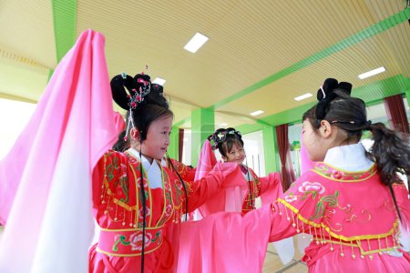 Téléchargez les photos : COMTÉ DE LUANNAN, province du Hebei, Chine - 8 mai 2019 : Les enfants de la maternelle interprètent Pingju, portant d'anciens vêtements colorés, ce qui est très intéressant. - en image libre de droit