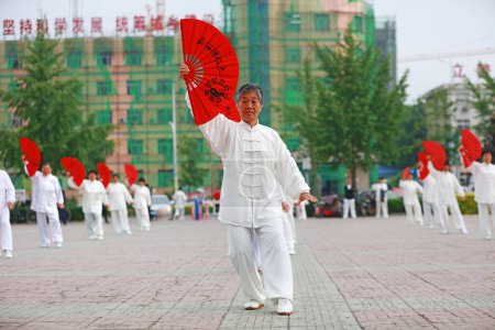 Photo for Luannan County - May 19, 2019: Chinese Tai Chi Kung Fu Fan Performing in Square, Luannan County, Hebei Province, China - Royalty Free Image