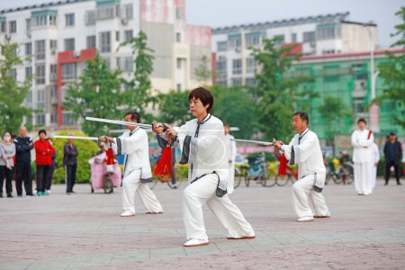 Photo for Luannan County - May 19, 2019: Chinese Tai Chi Sword Performing in Square, Luannan County, Hebei Province, China - Royalty Free Image