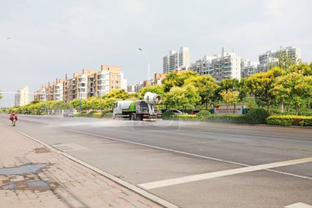 Photo for Luannan County, China - July 16th, 2019: professional vehicles in the street spray to reduce haze, Luannan County, Hebei Province, China. - Royalty Free Image