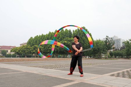 Foto de Condado de Luannan, China - 9 de julio de 2019: La gente agita cintas para ejercitarse en parques, Condado de Luannan, provincia de Hebei, China. Hoy en día, muchos chinos conceden gran importancia al ejercicio físico. - Imagen libre de derechos