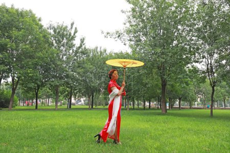 Téléchargez les photos : Comté de Luannan, Chine - 9 juillet 2019 : Les femmes dans les cheongsams jouent dans le parc, comté de Luannan, province du Hebei, Chine - en image libre de droit
