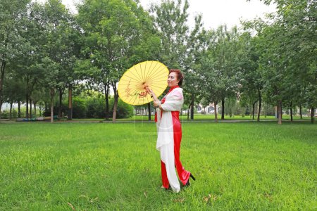 Foto de Condado de Luannan, China - 9 de julio de 2019: Mujeres en cheongsams juegan en el parque, Condado de Luannan, provincia de Hebei, China - Imagen libre de derechos