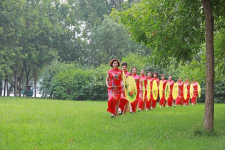 Téléchargez les photos : Comté de Luannan, Chine - 9 juillet 2019 : Les femmes dans les cheongsams jouent dans le parc, comté de Luannan, province du Hebei, Chine - en image libre de droit