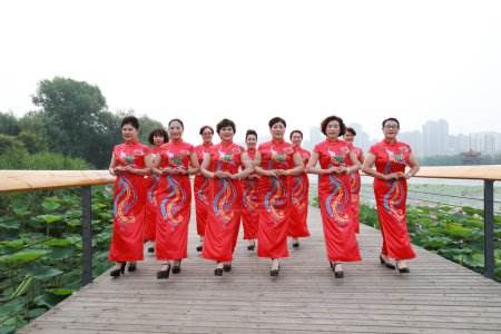 Téléchargez les photos : Comté de Luannan, Chine - 9 juillet 2019 : Des femmes en cheongsams rouges jouent dans un défilé, comté de Luannan, province du Hebei, Chine - en image libre de droit