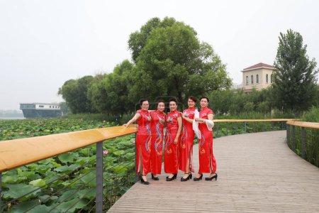 Foto de Condado de Luannan, China - 9 de julio de 2019: Mujeres con cheongsams rojos se presentan en un desfile, Condado de Luannan, provincia de Hebei, China - Imagen libre de derechos