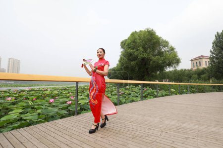 Foto de Condado de Luannan, China - 9 de julio de 2019: Mujeres con cheongsams rojos se presentan en un desfile, Condado de Luannan, provincia de Hebei, China - Imagen libre de derechos