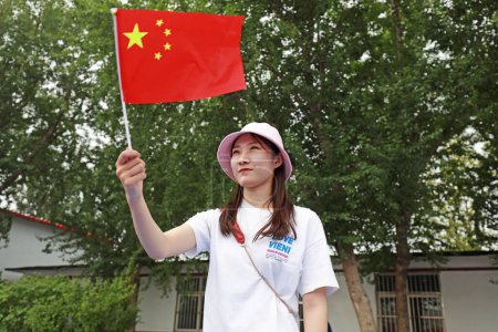 Foto de Condado de Luannan, China - 9 de julio de 2019: Una señora ondeó la bandera china, Condado de Luannan, provincia de Hebei, China - Imagen libre de derechos