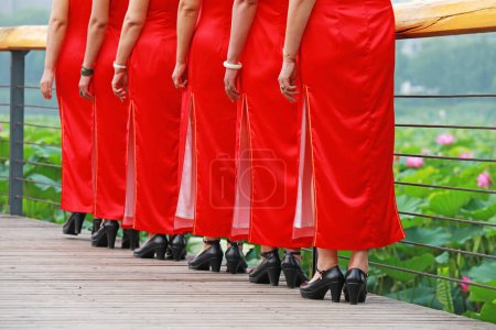 Photo for Women in red cheongsams are performing in a walk show, Luannan County, Hebei Province, China - Royalty Free Image