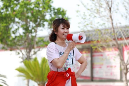 Téléchargez les photos : Comté de Luannan, Chine - 10 juillet 2019 : Une dame à la mode parle avec un haut-parleur à la main, comté de Luannan, province du Hebei, Chine - en image libre de droit