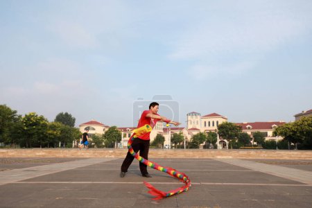 Téléchargez les photos : Comté de Luannan, Chine - 11 juillet 2019 : Les gens saluent Diabolo Dragon pour faire de l'exercice dans les parcs, comté de Luannan, province du Hebei, Chine. Diabolo Dragon est l'un des moyens traditionnels chinois de remise en forme folklorique. - en image libre de droit