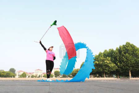 Foto de Condado de Luannan, China - 12 de julio de 2019: La gente agita cintas para ejercitarse en parques, Condado de Luannan, provincia de Hebei, China. Hoy en día, muchos chinos conceden gran importancia al ejercicio físico. - Imagen libre de derechos
