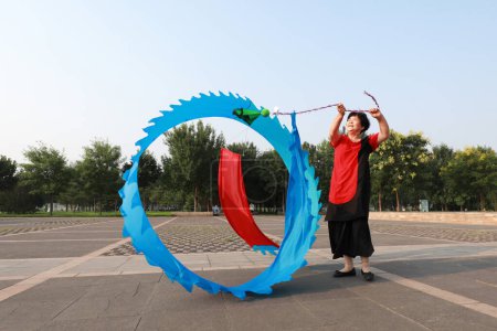 Foto de Condado de Luannan, China - 12 de julio de 2019: La gente agita cintas para ejercitarse en parques, Condado de Luannan, provincia de Hebei, China. Hoy en día, muchos chinos conceden gran importancia al ejercicio físico. - Imagen libre de derechos