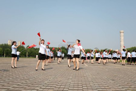 Foto de Condado de Luannan, China - 12 de julio de 2019: Damas caminando con bandera china en el parque, Condado de Luannan, provincia de Hebei, China - Imagen libre de derechos